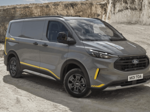 A grey, black and yellow Ford Transit Custom Trail parks sideways in an off-road setting